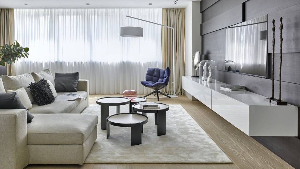 Серый диван в интерьере гостиной по ассиметричной схеме